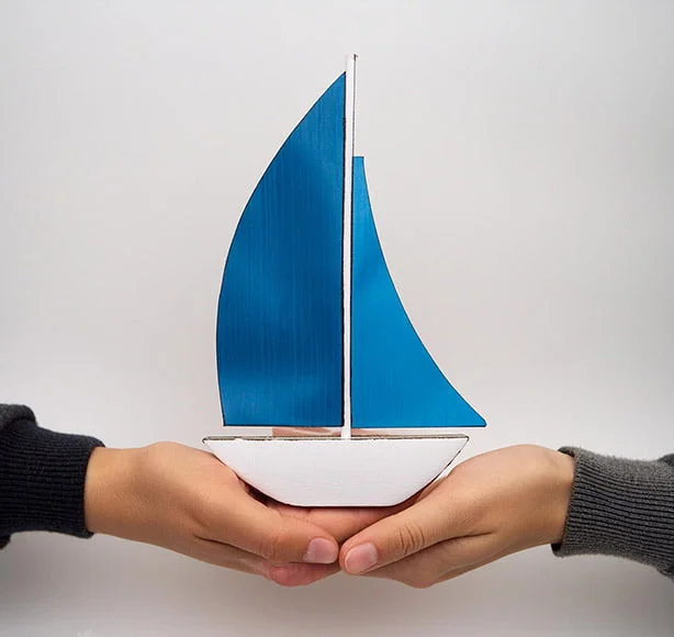 hands-holding-sailboat